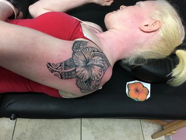 Woman lying on side with fresh tattoo on shoulder.