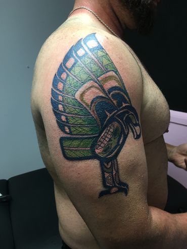 Detailed tribal tattoo on upper arm.