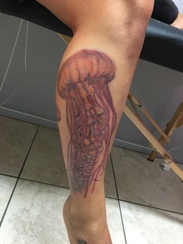 Tattoo of a jellyfish on a leg.