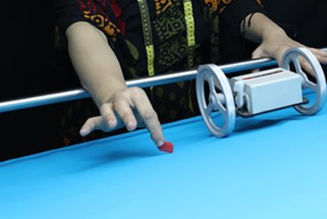 Person chalking cue tip on pool table before a shot.