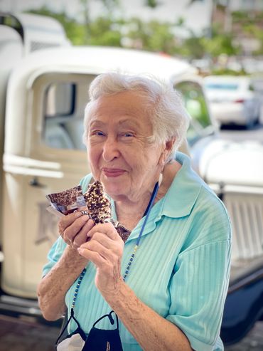 Elderly lady smiling while eating Ice Cream pop from Karmic Ice Cream truck in Parkland Florida