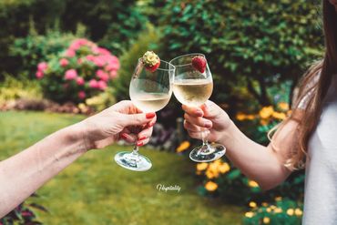 A man and woman changing with a glass of wine in the garden.