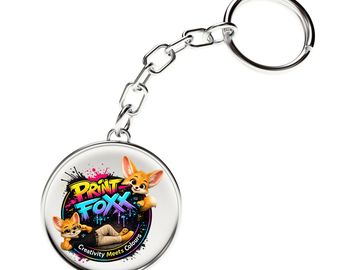 Metal keychain with colorful PRINT FOXX design and cartoon fox characters.