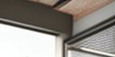 Modern office interior with large windows and exposed ceiling.