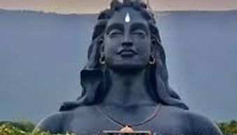 Massive black statue of Lord Shiva with people at its base.