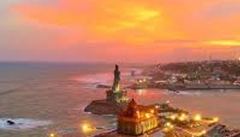 Sunset view of the Vivekananda Rock Memorial surrounded by sea waves.