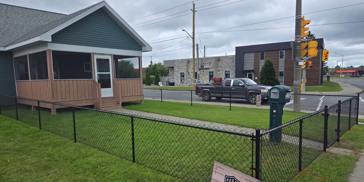 Professional fence company adjusting gate hardware for smooth operation