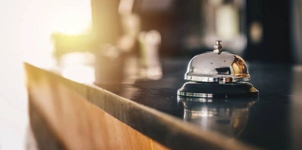 A shiny service bell on a polished countertop in soft natural light.