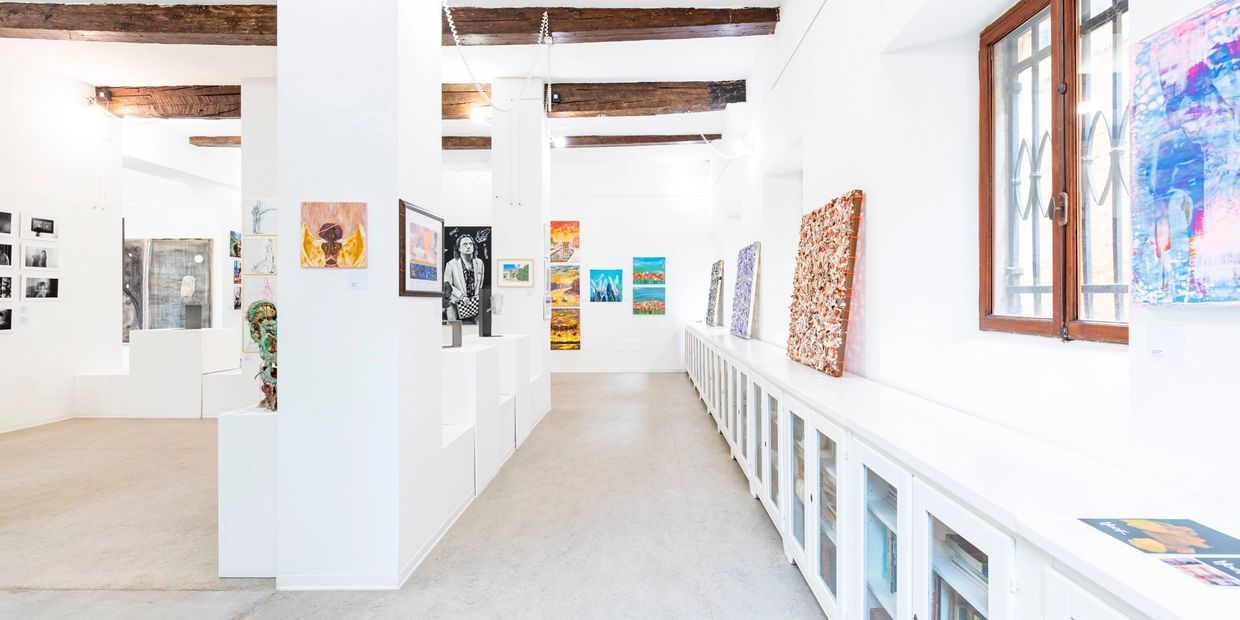 Bright, spacious art gallery with diverse paintings and sculptures.