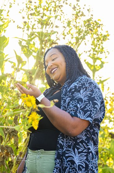 Smiling woman enjoying a sunny day in a flower field.