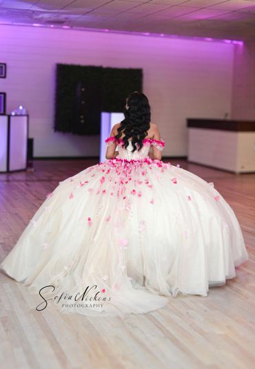 Woman in a voluminous white gown with pink floral details.