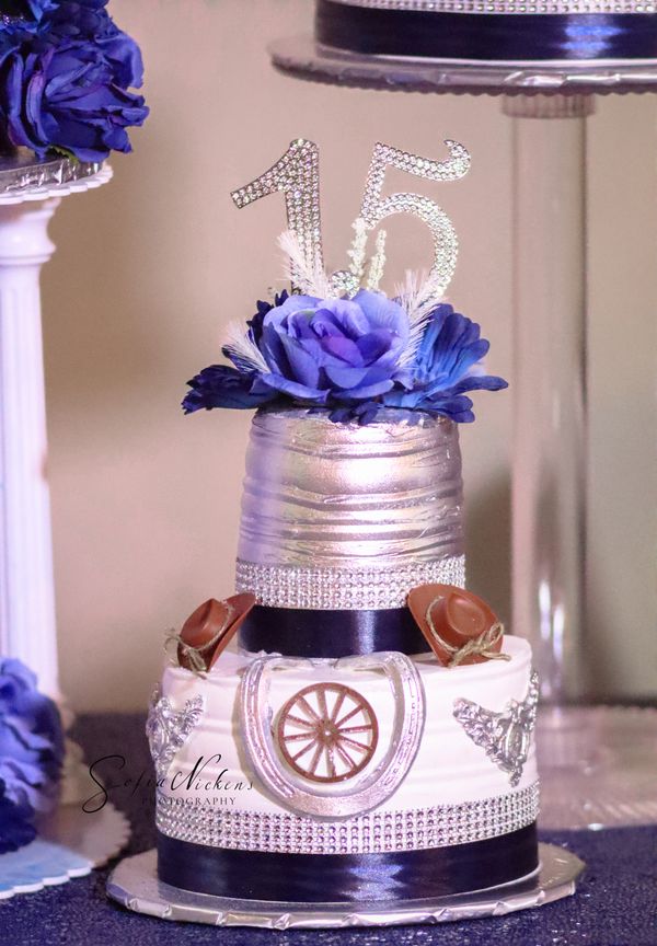 Elegant silver and blue two-tier quinceañera cake with cowboy hats.