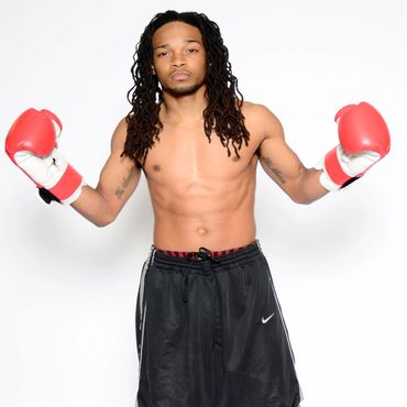 A man wearing a boxing glove looking at the camera