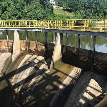 Hydroelectric dam structure in a lush green area.
