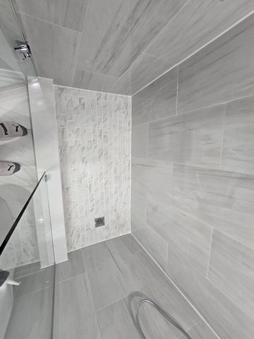 Modern tiled shower with clean caulking lines along walls and tub