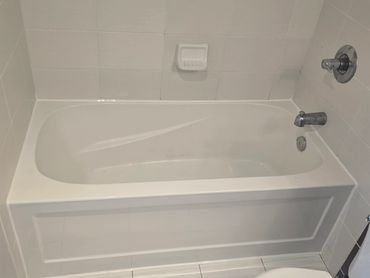 White bathtub with freshly caulked perimeter joints.
