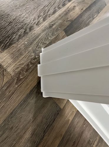 Baseboard corner with caulking applied to fill gaps along floor edge