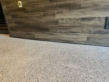 Durable sealant applied along a epoxy floor and wall joint to close visible gaps.