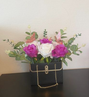 Vase with purple and white roses and butterflies.