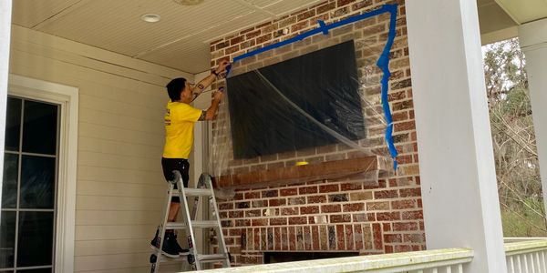 Employee covering a flat screen tv with plastic