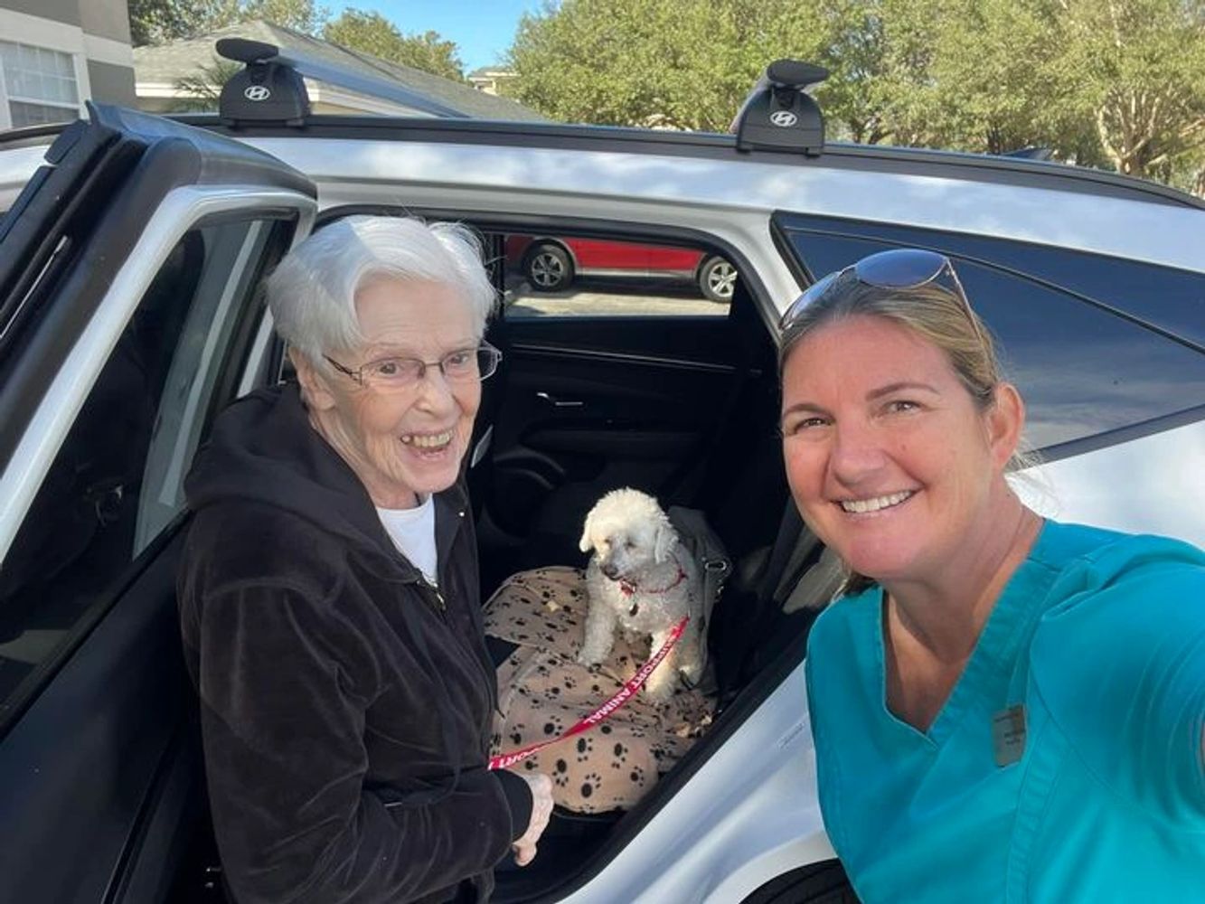 RN Nurse placing senior in assisted living with a white dog