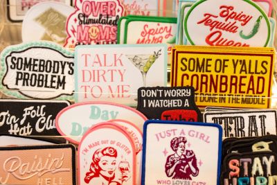 A collection of colorful humorous patches with various sayings and designs.