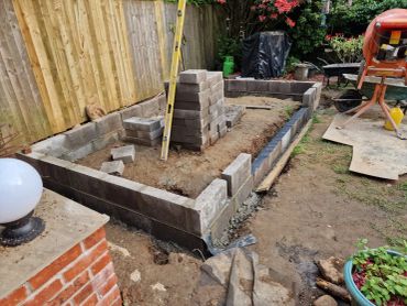 Backyard construction with cinder blocks and cement mixer.