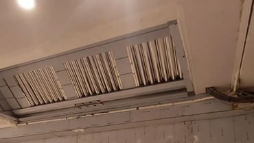Ceiling with recessed lighting and exposed wiring in a room under construction.