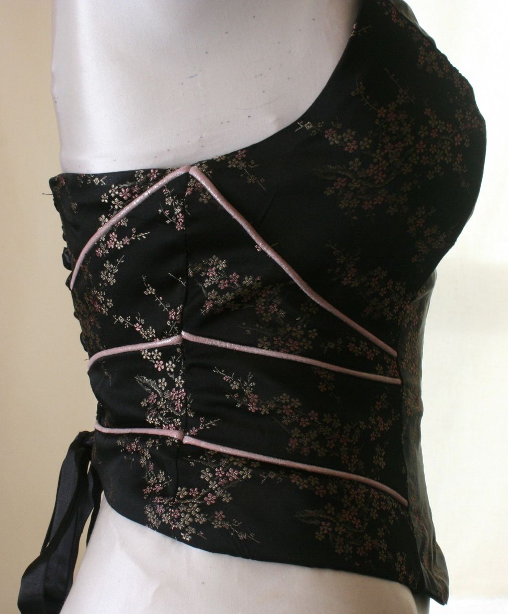 Satin corset with leather piping.