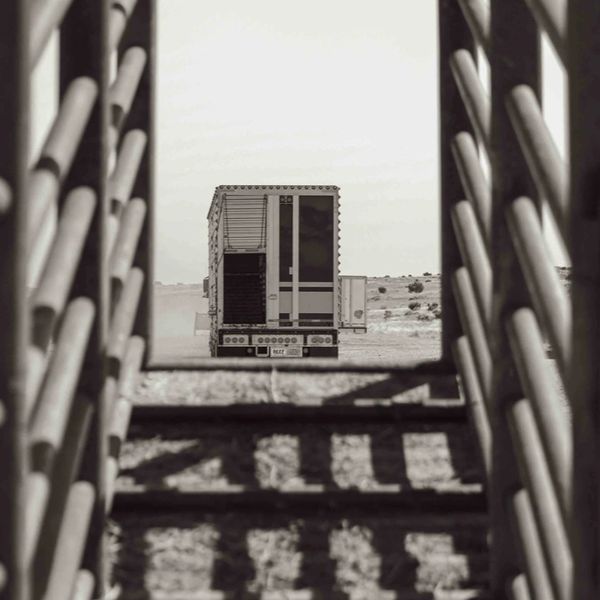 Black and white photo of a truck framed by metal bars.