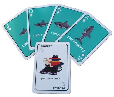 Playing cards featuring sharks and a protect card with cats and books.