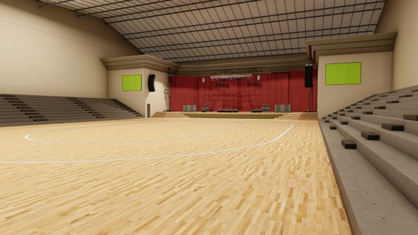 Empty indoor basketball court with seating and stage.