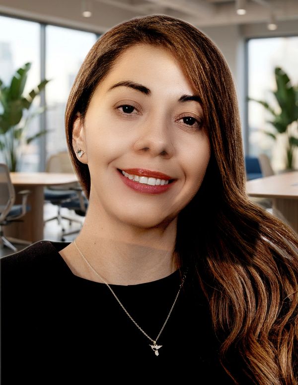 Mujer sonriente con cabello largo en oficina moderna.