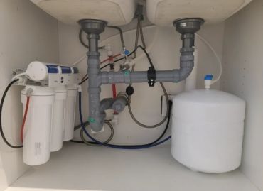 Under-sink reverse osmosis drinking water system with storage tank.