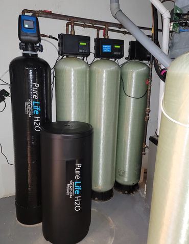 Whole-home water treatment system with water softener and multiple filtration tanks.