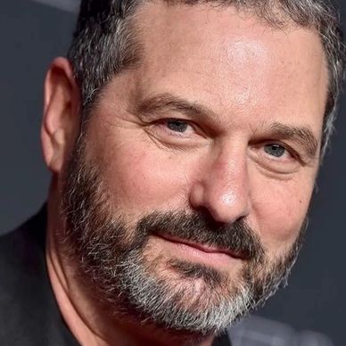 Close-up of a bearded man with a slight smile at an event.