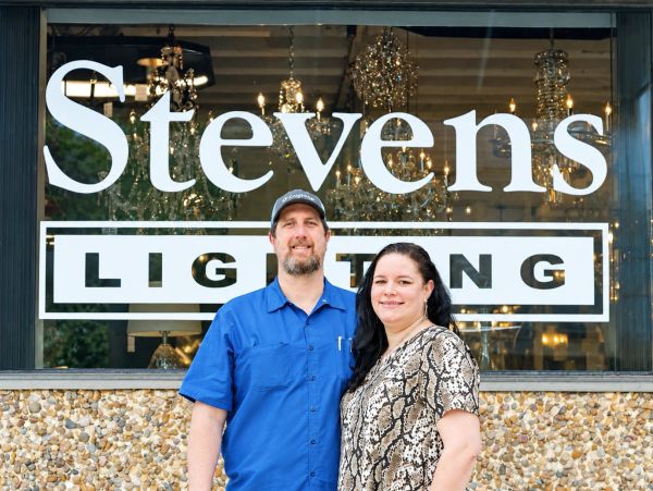 A couple stands in front of Stevens Lighting store.