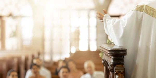 Priest addressing congregation in church.