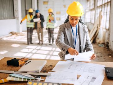 Contractor and client reviewing a project blueprint.