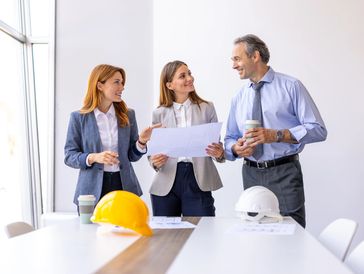 Workers on a construction site looking at blueprints.