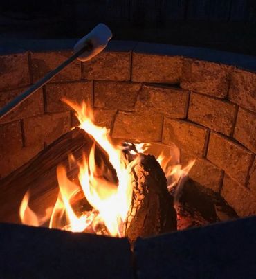 Toasting marshmallows over fire pit.