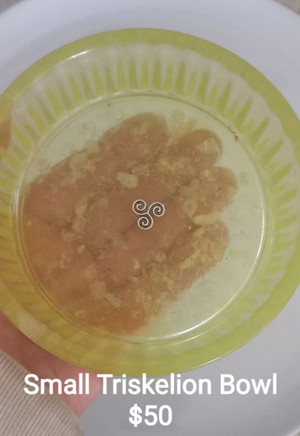 Small yellow triskelion bowl with design and text