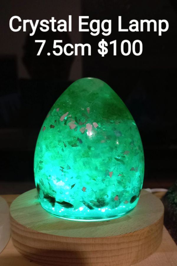 Glowing green crystal egg lamp on a wooden base, 7.5cm, priced at $100.