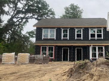 Two-story house under construction with black sheathing.