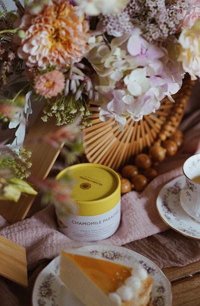 Cozy tea setup with flowers and cake.