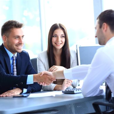 Three professionals shaking hands in a business meeting.