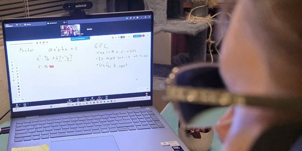 Person attending an online math class on a laptop.