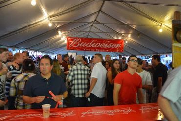 Group of people in the beer tent with a Budweiser banner above their head