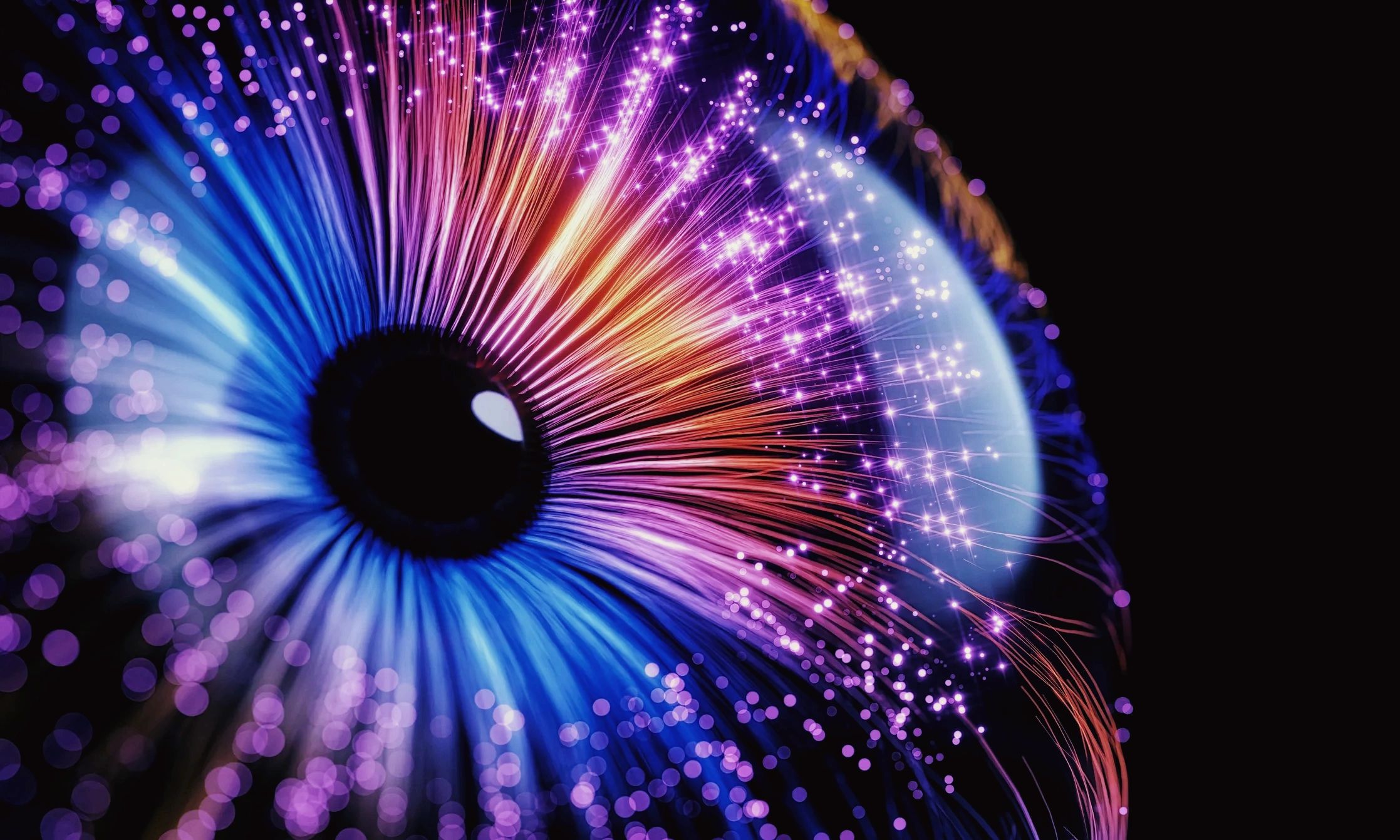 Close-up of a glowing, colorful fiber optic eye with vibrant lights.