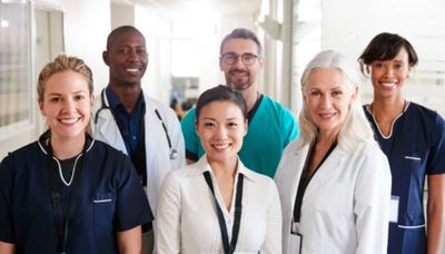 A diverse group of smiling healthcare professionals posing together.